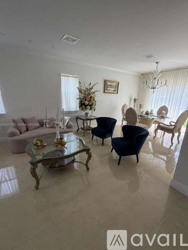 A living room with a glass coffee table and a chandelier.