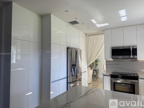 A modern kitchen with a stainless steel refrigerator and oven.