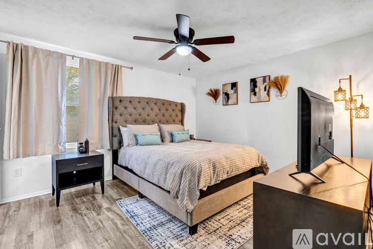 A bedroom with a large bed and a ceiling fan.