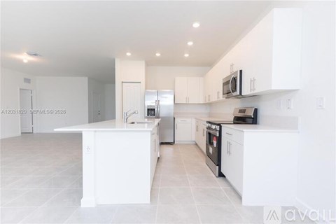 A modern kitchen with white cabinets and appliances.