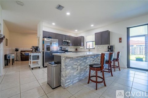 A kitchen with a bar area and a dining table.