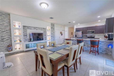 A modern dining room with a stone fireplace and a large table set for six.