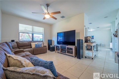 A living room with a brown couch and a flat screen TV.