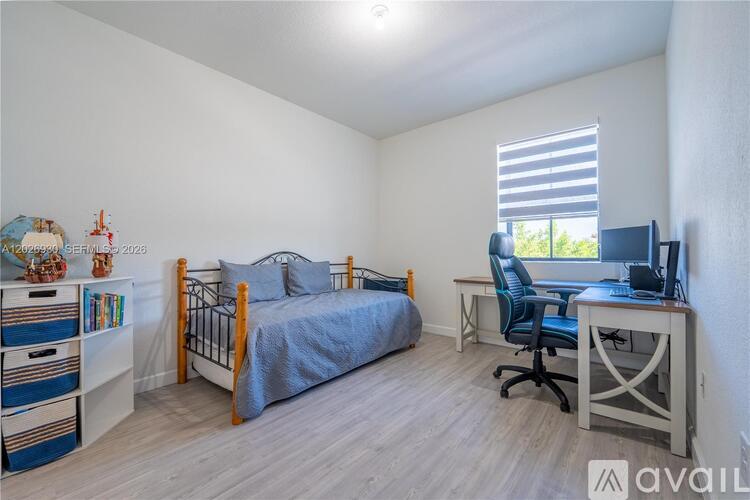 A bedroom with a bed, desk, and chair.