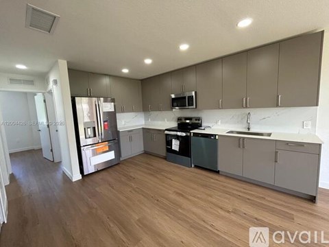 A kitchen with wooden floors and a refrigerator with a water dispenser.
