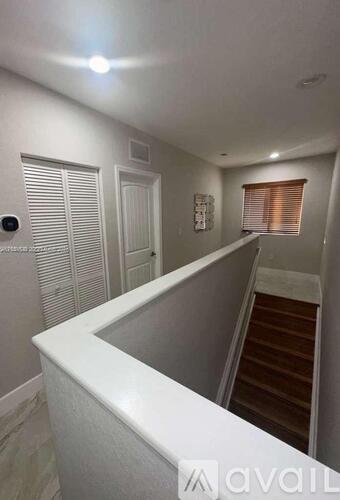 A hallway with a staircase leading to the second floor.
