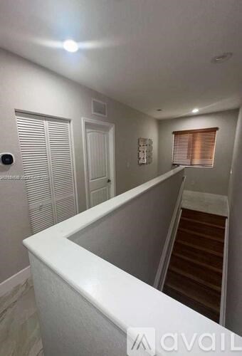 A hallway with a staircase leading to the second floor.
