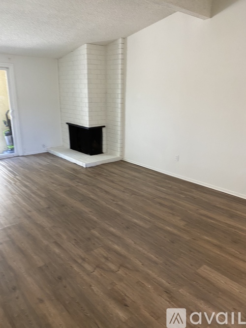 A room with a fireplace and wooden flooring.