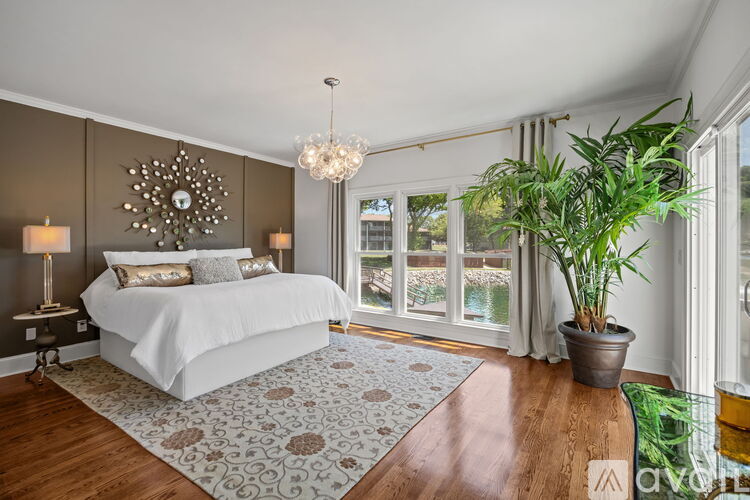 A bedroom with a large bed and a chandelier.