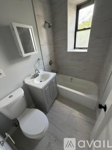 A bathroom with a toilet, sink, and tub.