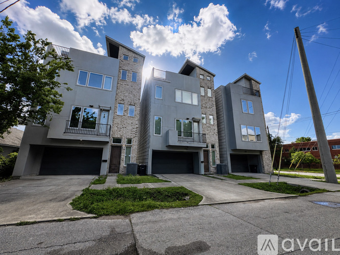 A modern multi-story residential building with a clear blue sky above.