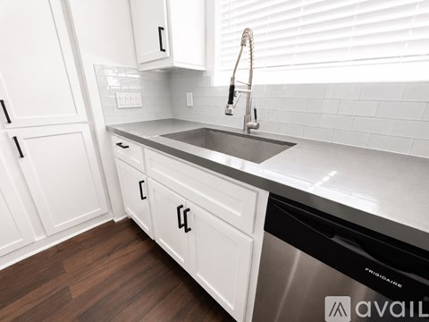A kitchen with white cabinets and a stainless steel dishwasher.