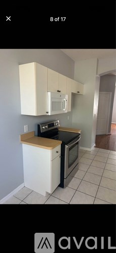 A kitchen with white cabinets and a black stove top oven.