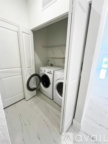 A white laundry room with a washer and dryer in it.