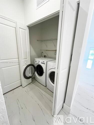 A white laundry room with a washer and dryer in it.