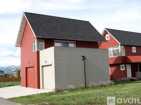 A red barn with a garage door and a sign that says "available".