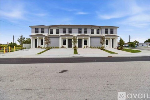 A large, two-story house with a grey facade and white trim is available for rent.