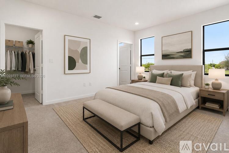 A well-lit bedroom with a large bed and a clothing rack.