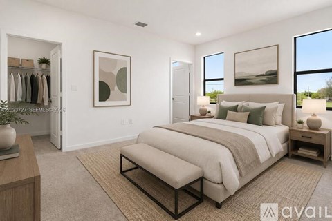 A well-lit bedroom with a large bed and a clothing rack.