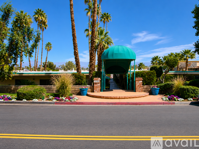 A blue dome structure is surrounded by palm trees and plants.
