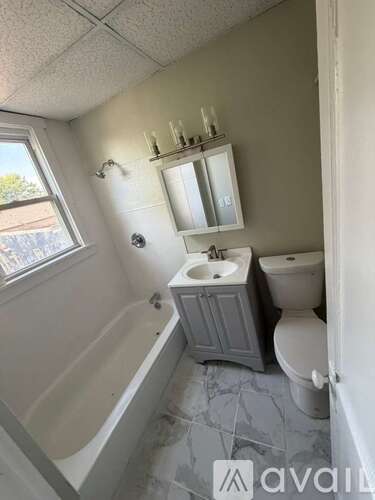 A bathroom with a tub, toilet, and sink.
