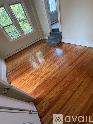 A room with wooden flooring and a window.