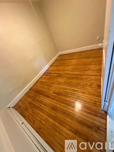 A wooden floor in a room with white walls.