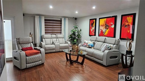 A living room with a grey sofa, a white armchair, and a wooden coffee table.