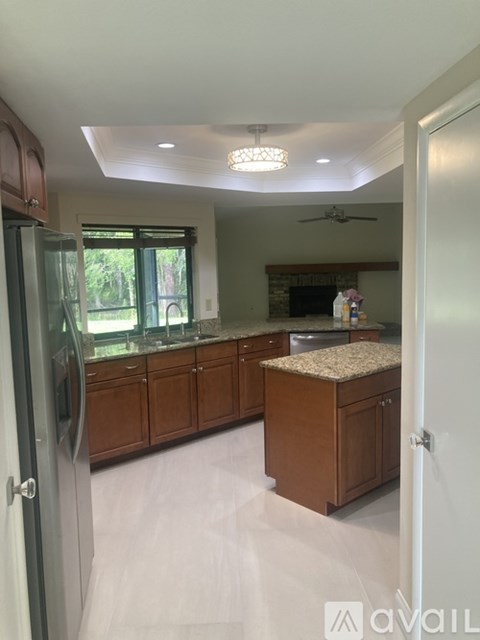 A kitchen with wooden cabinets and a granite countertop.