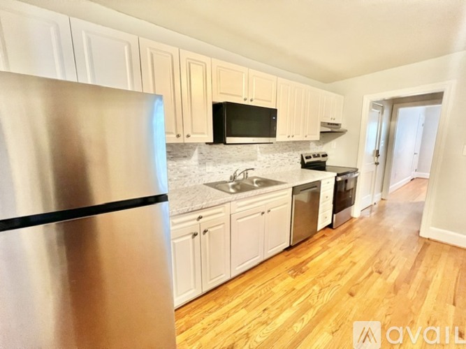 A kitchen with a stainless steel refrigerator, microwave, oven, and sink.