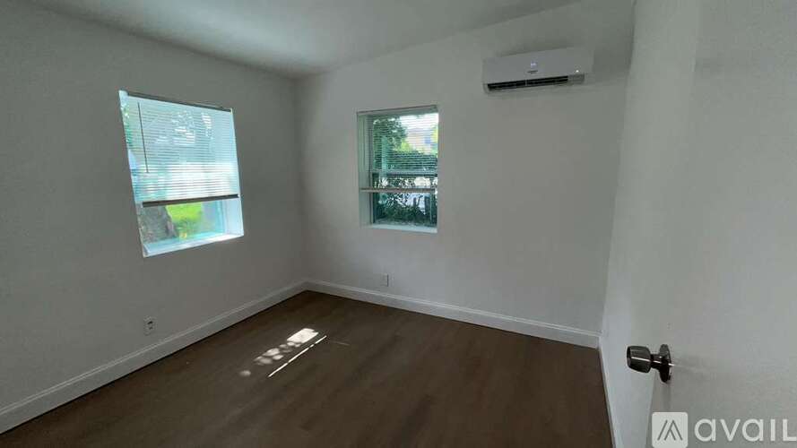 A room with a window and a door is available for rent.