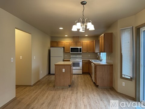 A kitchen with wooden cabinets and a white refrigerator.
