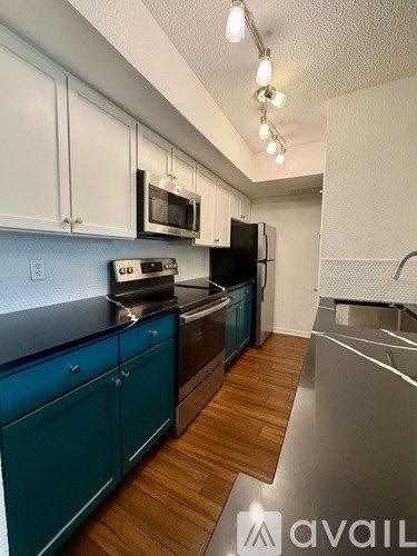 A kitchen with blue cabinets and stainless steel appliances.