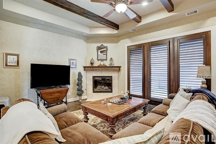 A living room with a fireplace and a television.