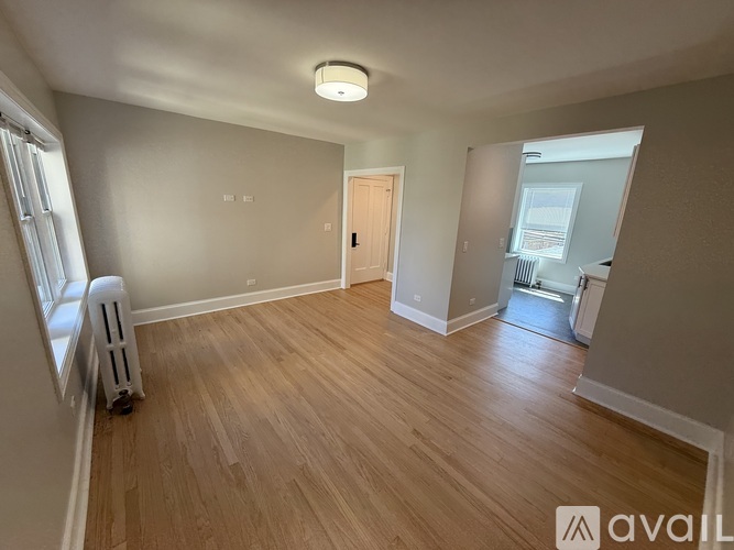 A room with wooden flooring and a white ceiling with a light fixture.