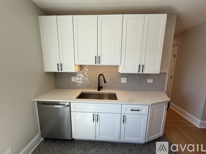 A kitchen with white cabinets and a stainless steel dishwasher.