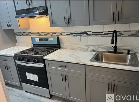 A kitchen with a black stove top oven and a marble countertop.