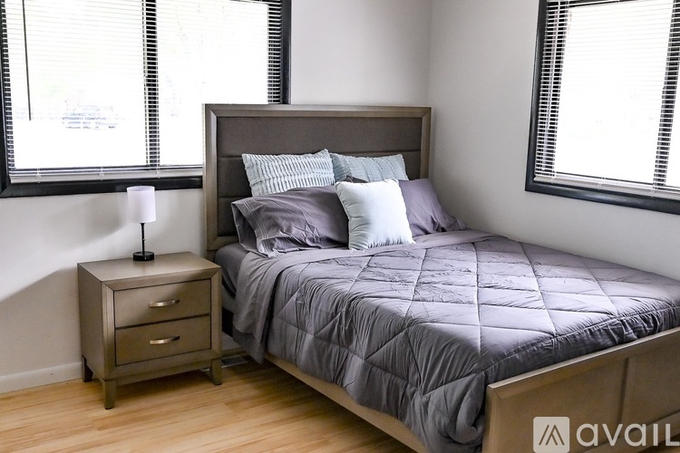 A bedroom with a bed, nightstand, and window.
