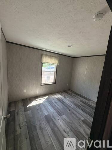 A spacious room with grey carpeting and wooden paneling.