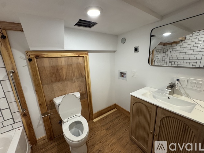 A bathroom with a toilet, sink, and mirror.