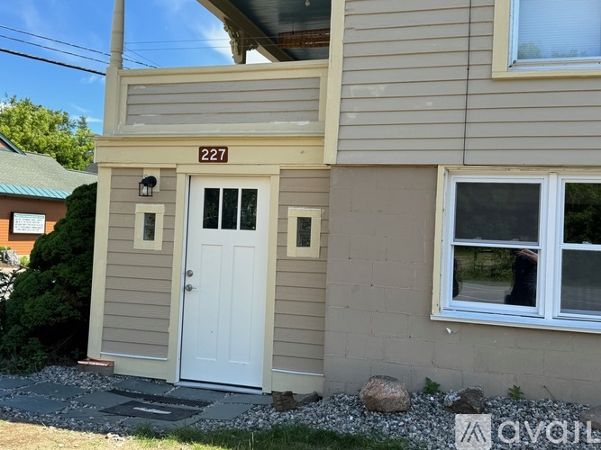 A house numbered 227 with a white door and windows.