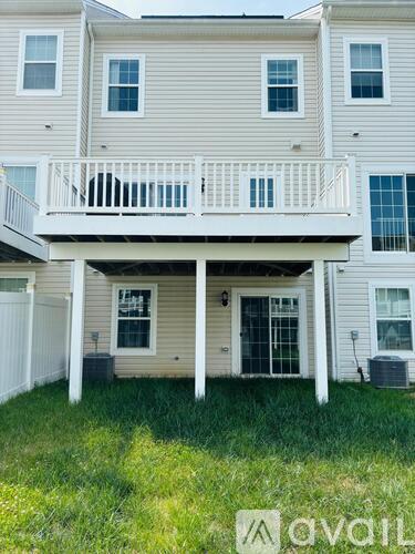 A two-story building with a balcony and a white fence.