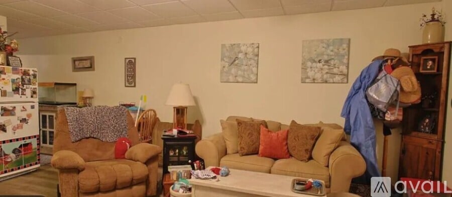 A living room with a couch, chair, and a table with a lamp on it.