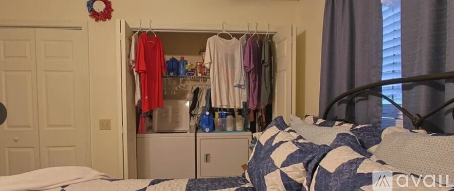 A bedroom with a bed, a wardrobe, and a window.