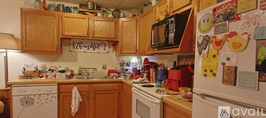 A kitchen with wooden cabinets and a white fridge covered in magnets.