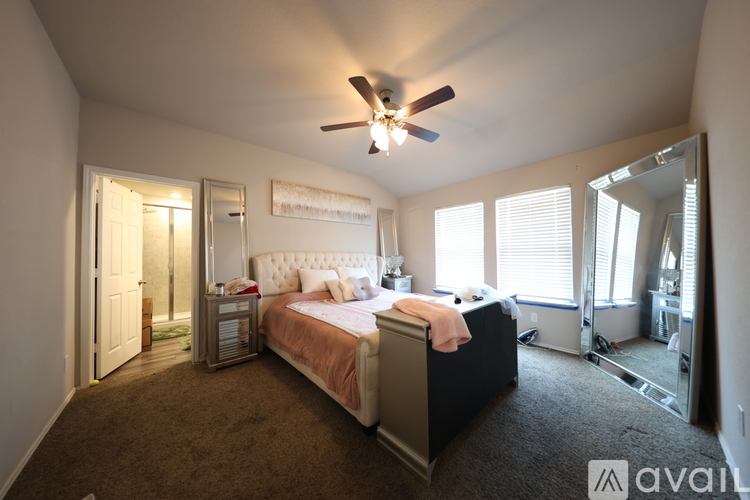 A bedroom with a bed, dresser, and mirror.