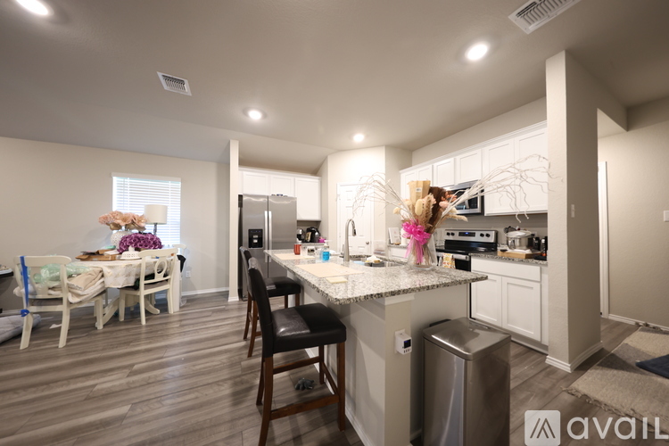 A kitchen with a dining table and chairs.