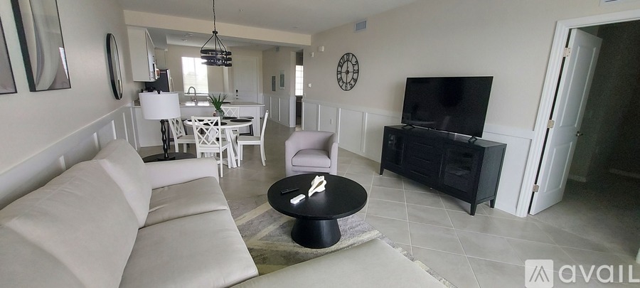 A living room with a white couch and a black coffee table.