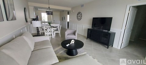 A living room with a white couch and a black coffee table.