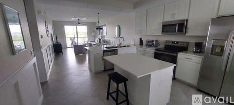 A kitchen with white cabinets and appliances.